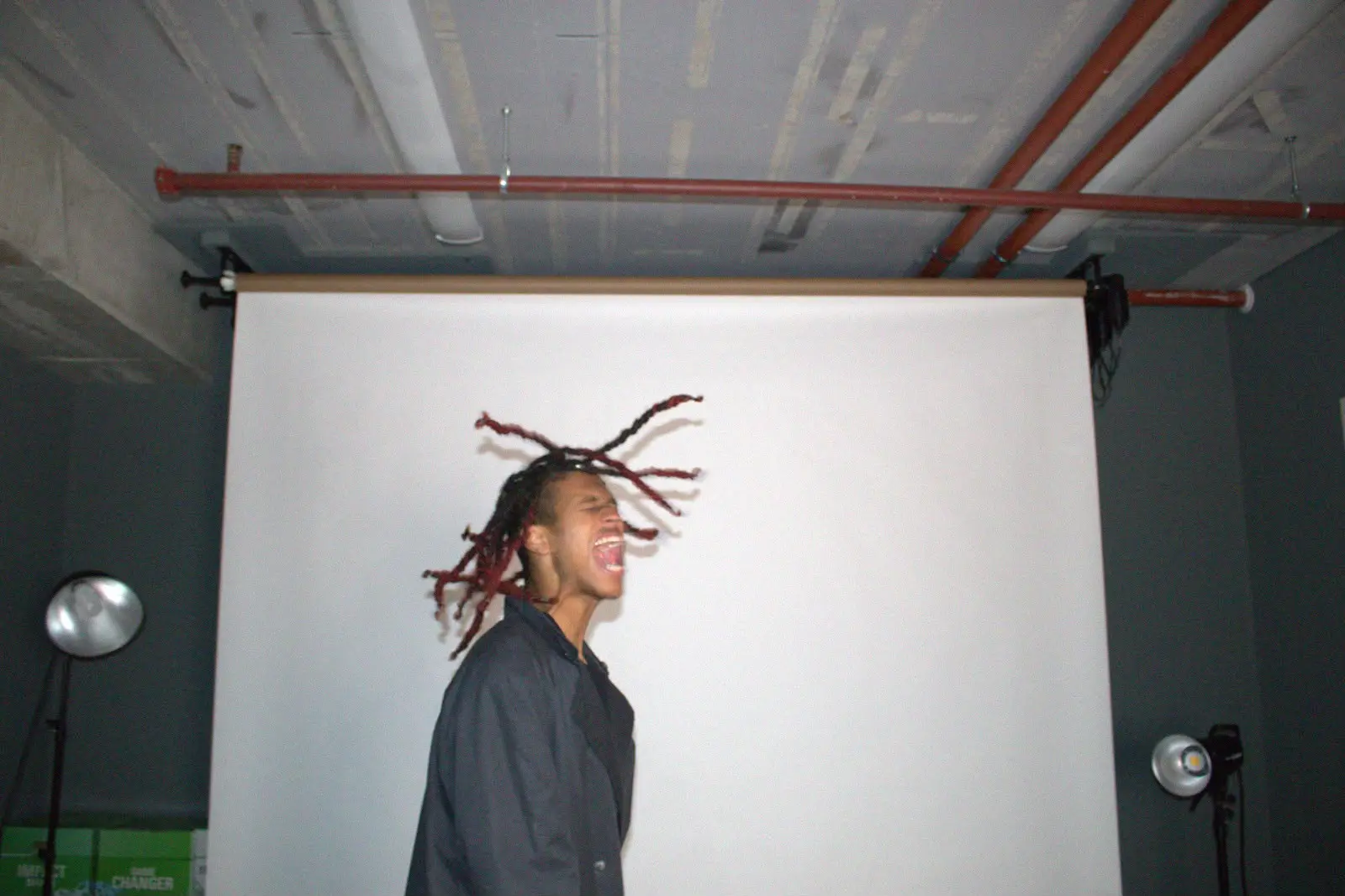 Artist mid-scream with hair in motion under studio lights